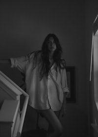 a black and white photo of a woman standing on a staircase